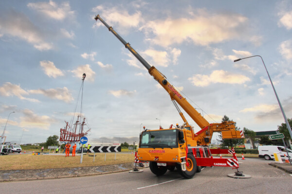 close up of mobile crane lifting steel sculpture