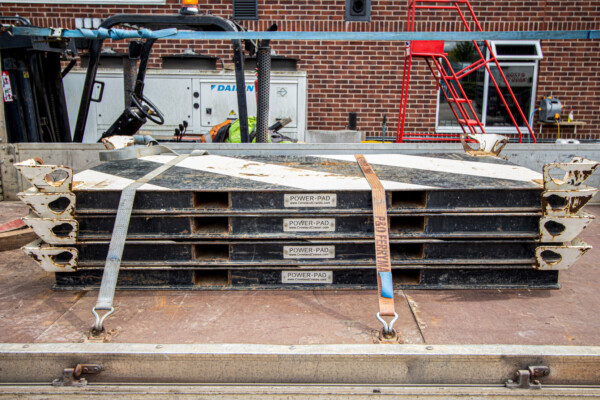 steel spreader mats for a mobile crane are stacked on the back of a transportation lorry