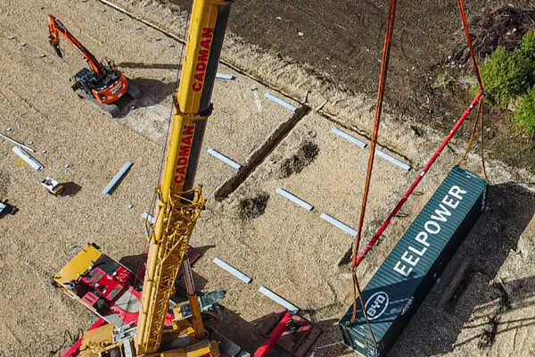 aerial shot of mobile crane moving container with specialist beams