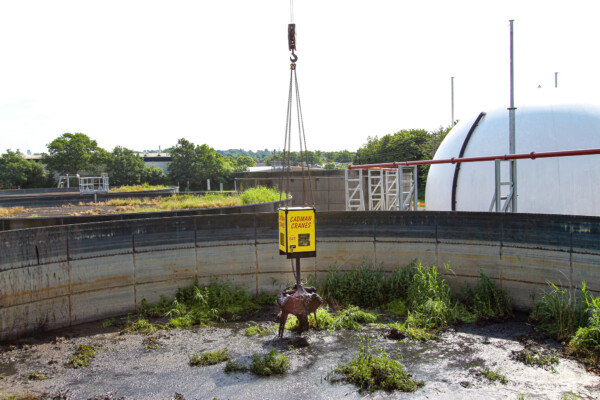 Close up of a grab removing waste from a water treatment tank
