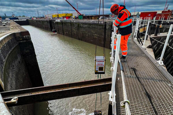 A crane operator looks down at a grab working in a river