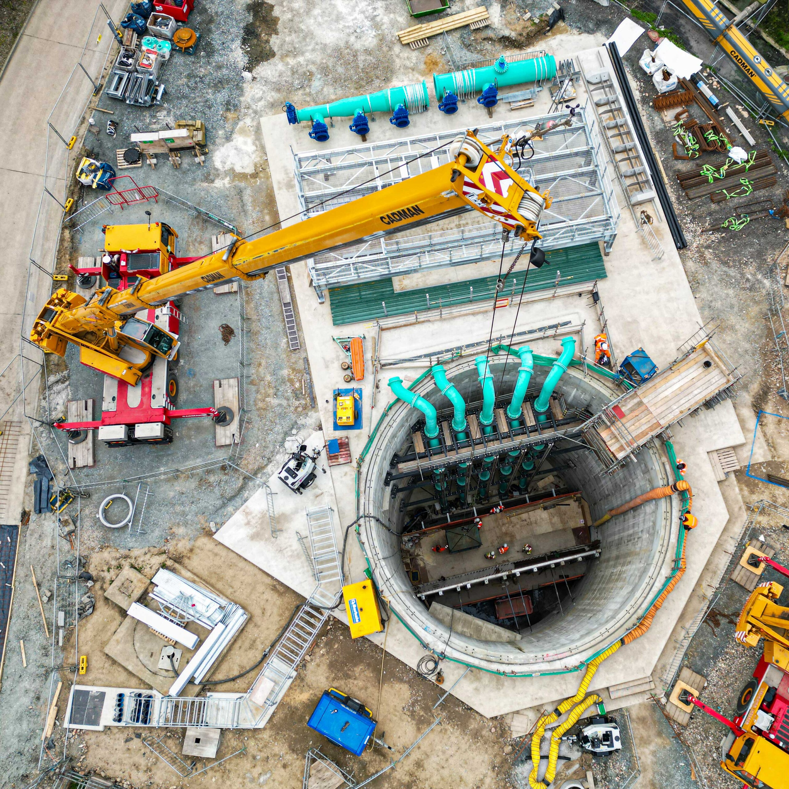 aerial view of mobile crane installing pipe work into wastewater facility