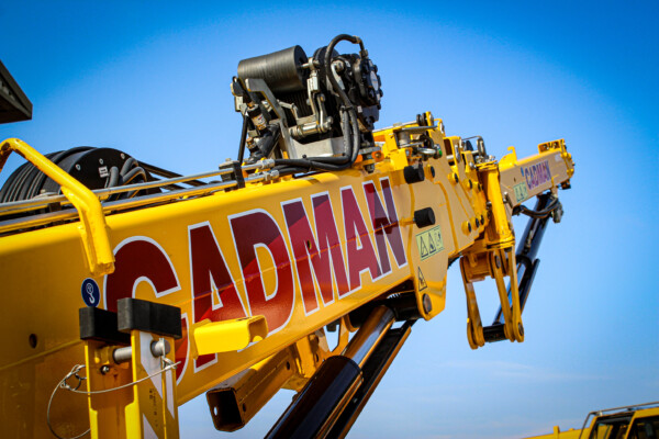 yellow hoeflon c10 spider crane boom with blue sky background