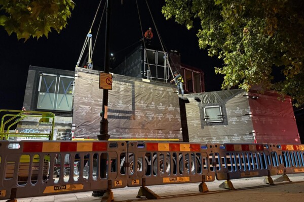 Modular building installed with mobile crane during night road closure in London