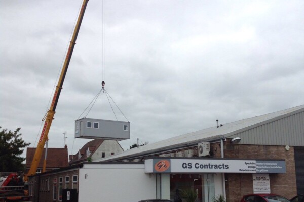 Modular portacabin building installed with mobile crane on construction site