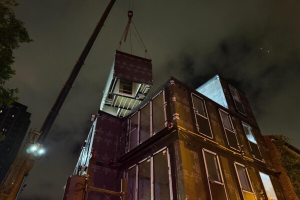 Mobile crane installs modular building on roof during overnight works with road closure