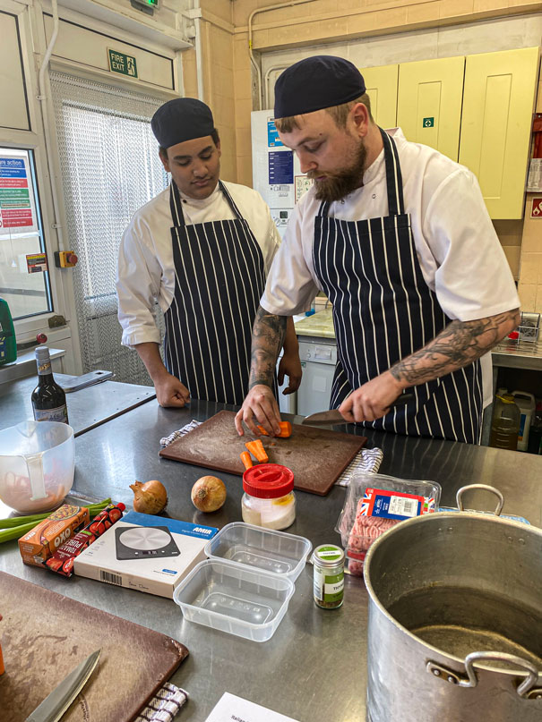 Young men cooking in kitchen at lads need dads event